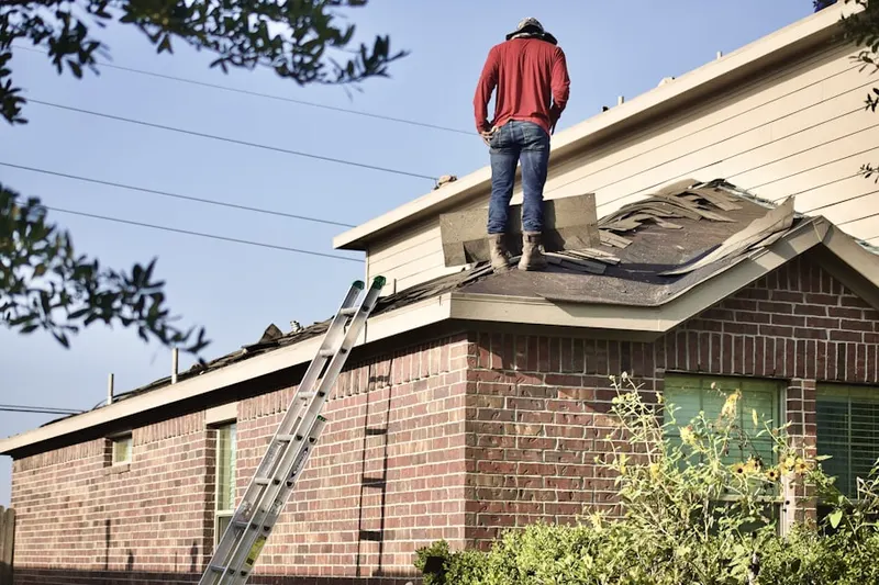 Professional roofer working on a residential roof in Buttonwood Farms